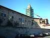 Foto 19 - Resti della seconda cerchia muraria lungo via Dante. Il campanile sullo sfondo appartiene alla chiesa di S. Francesco. Le abitazioni sono di pertinenza della canonica